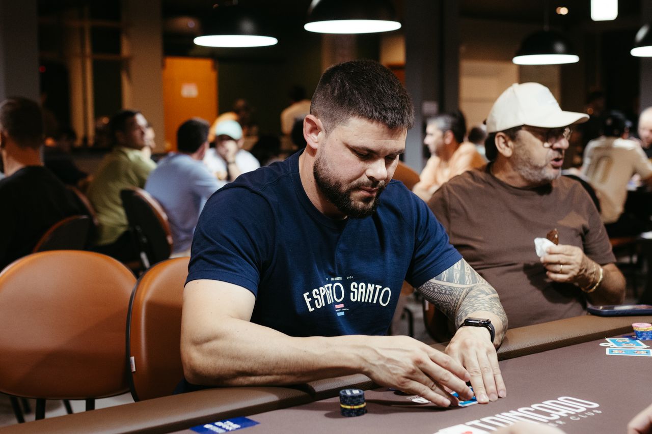 A poker player concentrating during a game in a lively casino atmosphere.