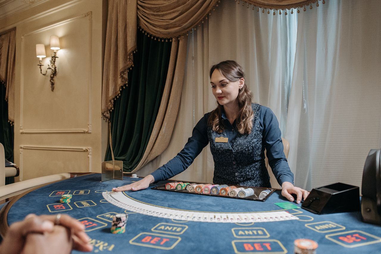 who-we-are Casino dealer managing cards and chips in an elegant gambling setting.